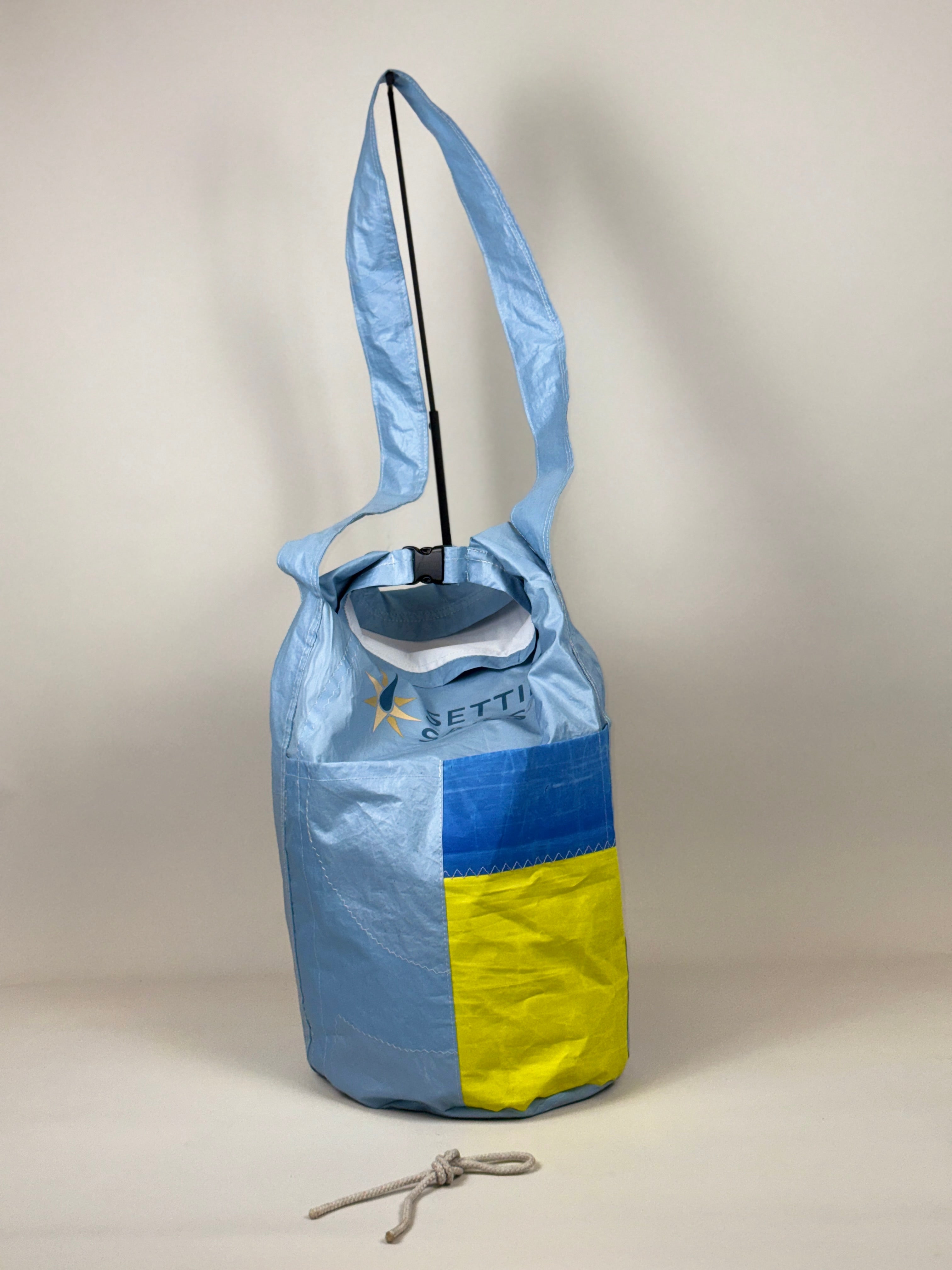 Plunjetas van lichtblauw gerecycled jachtzeil met blauw en geel vlak, achterkant en opening