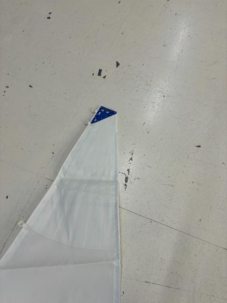 Top van het grootzeil met blauwe versterkingshoek in de kop